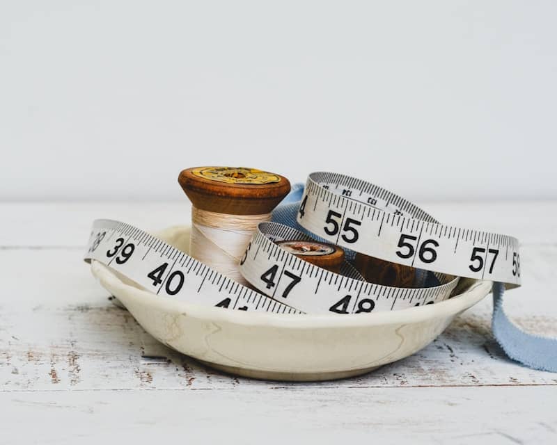 Spools and measuring tape in a decorative dish.