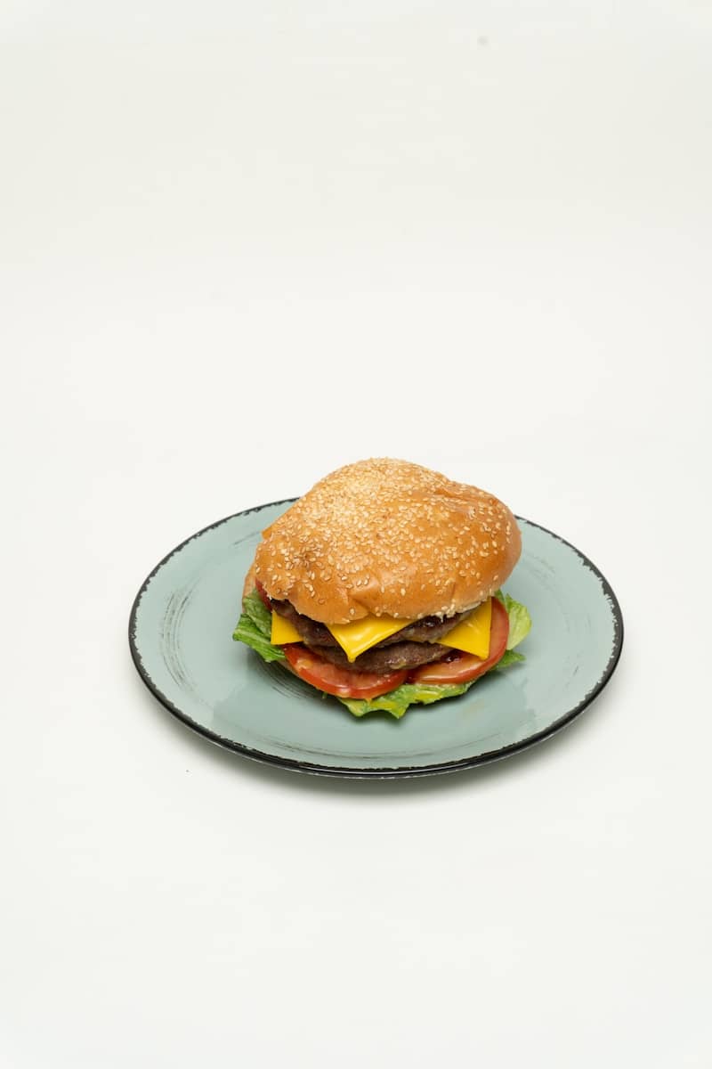 A cheeseburger rests on a light blue plate.