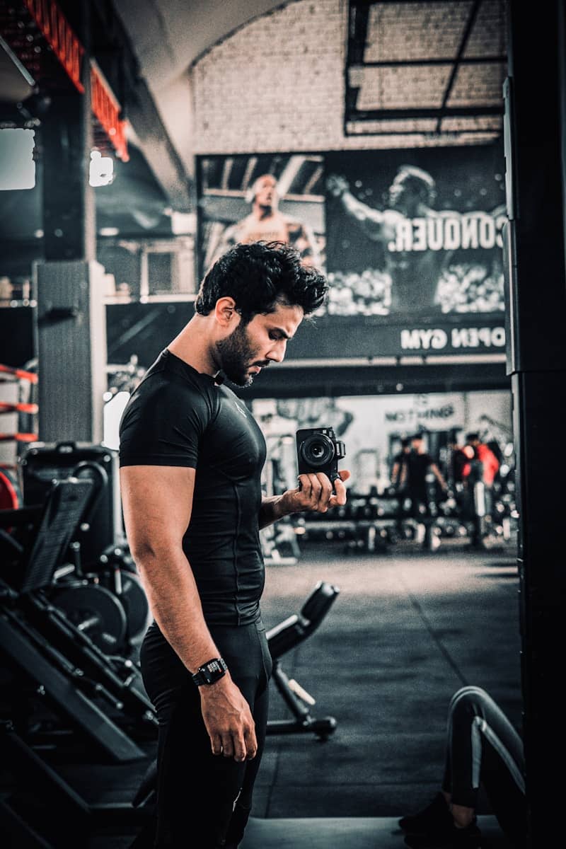 Man takes a gym selfie in front of a mirror.