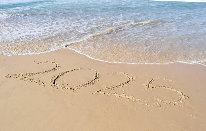 A sandy beach with the word summer written in the sand