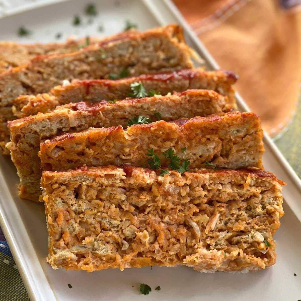 Sliced chicken meatloaf on a platter.