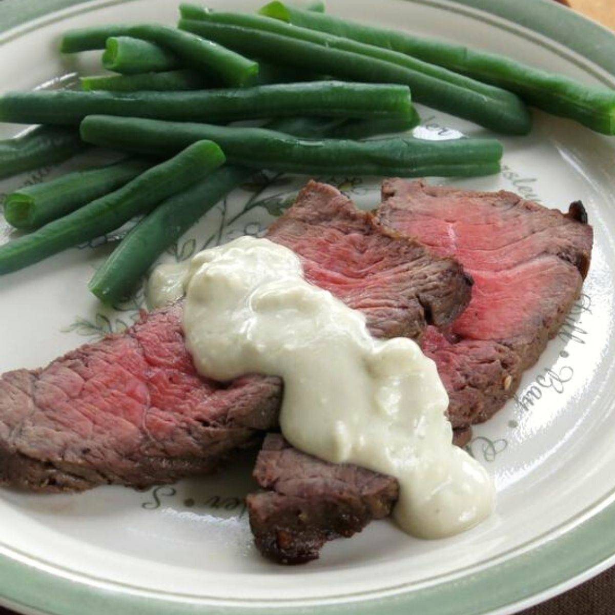 Two slices of london broil with blue cheese on top.
