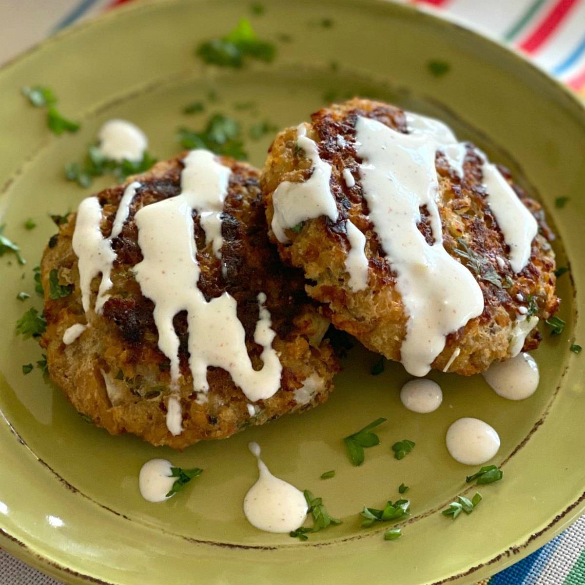 Baked salmon cakes on a green plate.