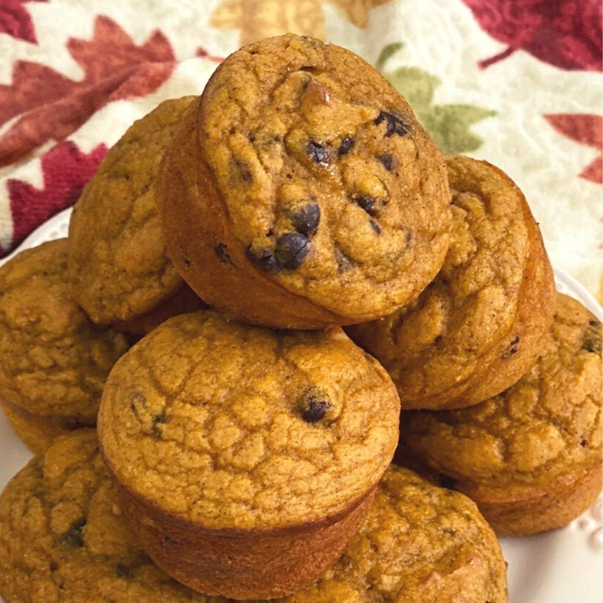 Stack of pumpkin muffins on a fall napkin.