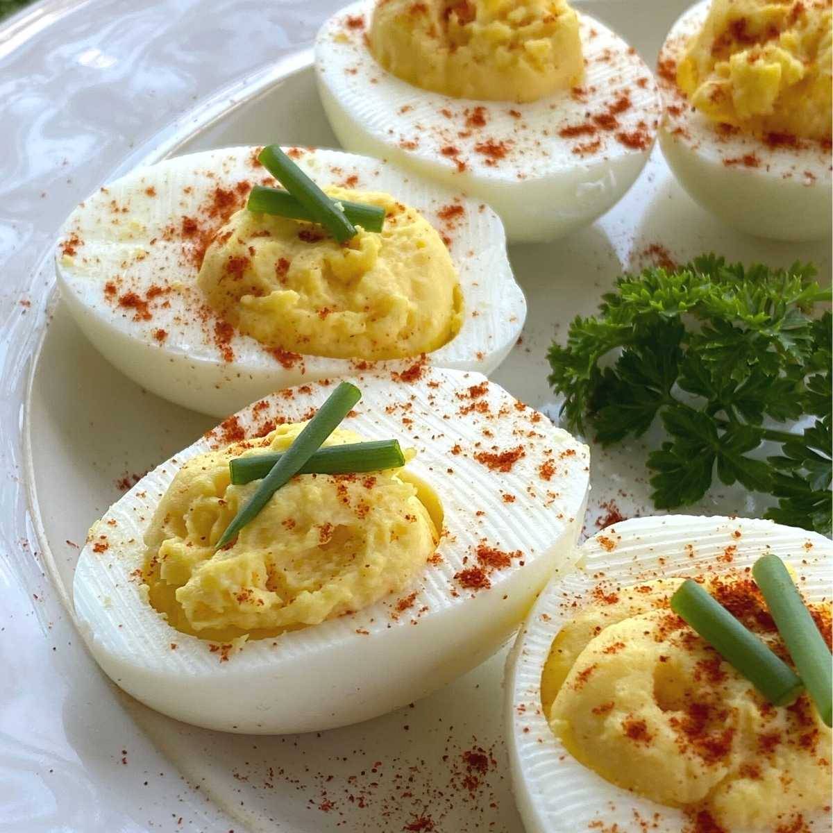 Five deviled eggs on a platter with parsley.
