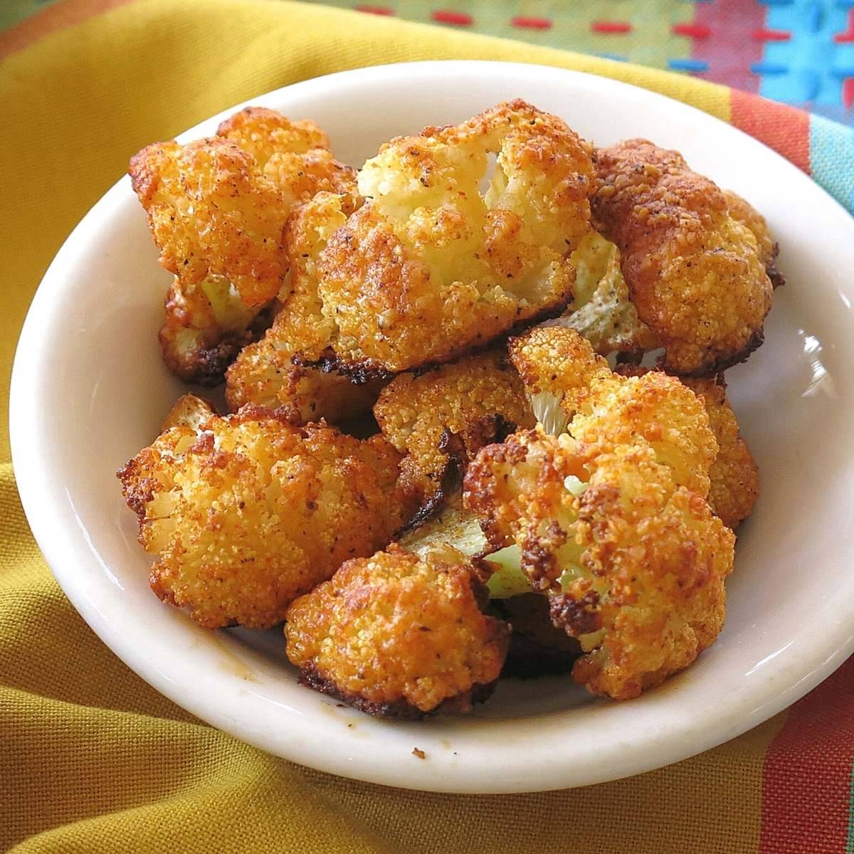 Parmesan cauliflower bites in a white bowl.