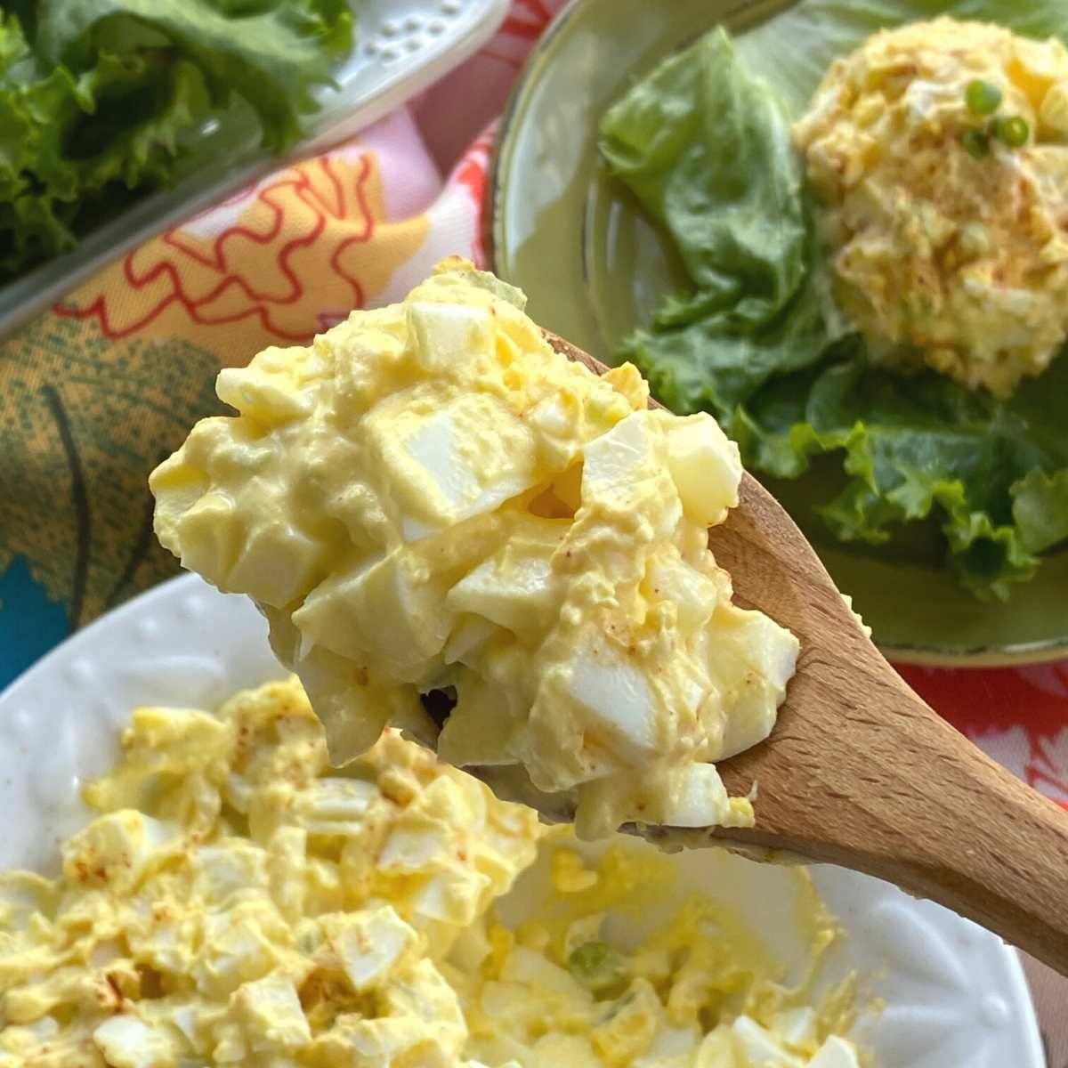 Egg salad on a wooden spoon.