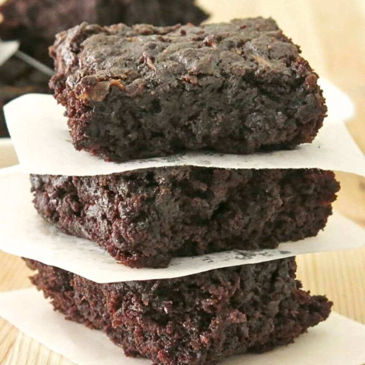Three zucchini brownies stacked on top of each other.