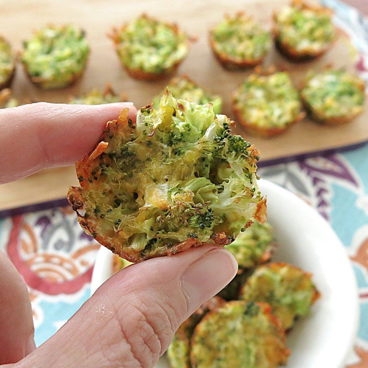 Fingers holding a broccoli cheddar egg muffin.