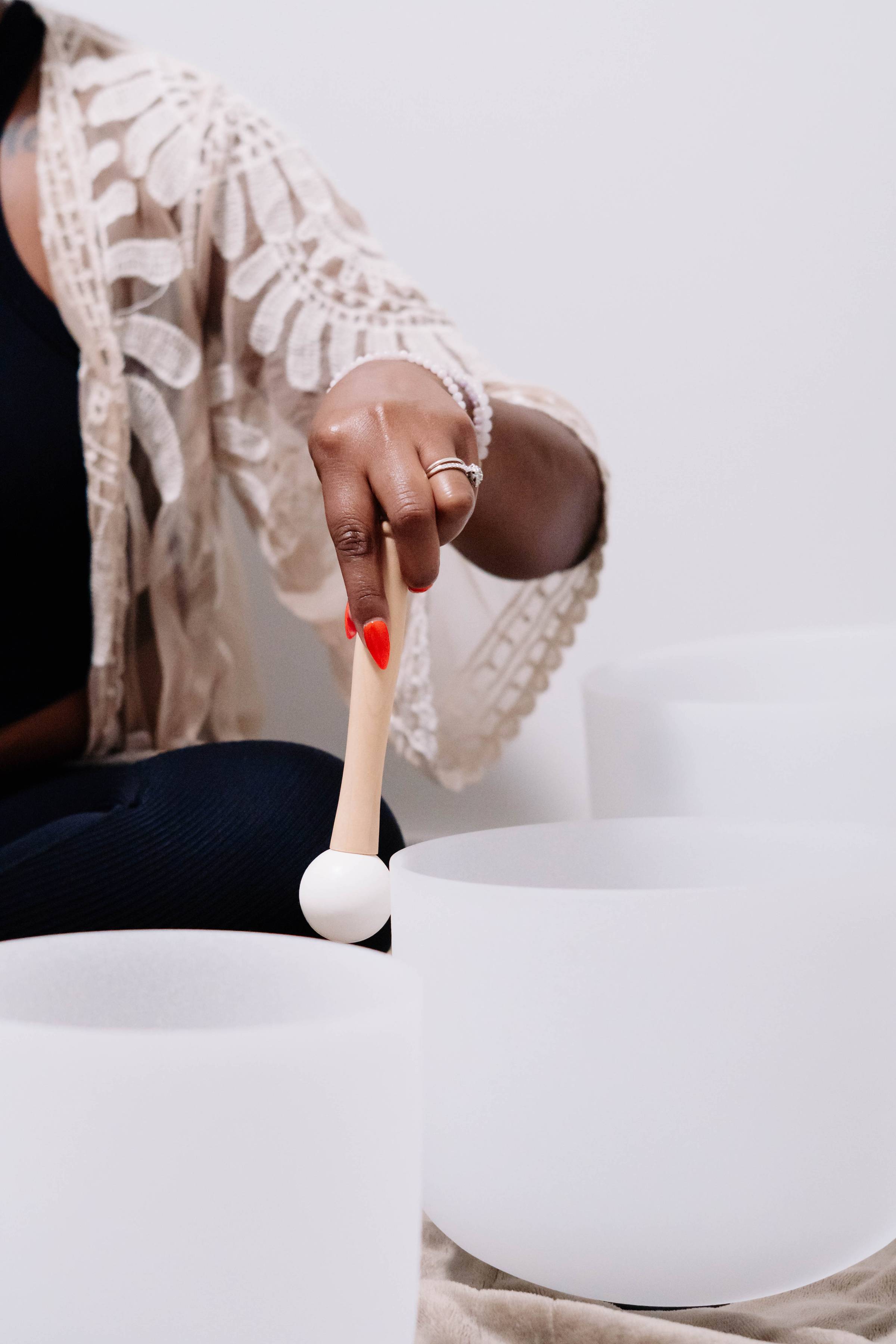 Mallet striking a crystal singing bowl during a sound bath session