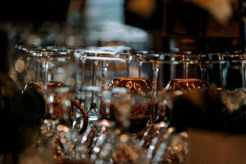 Glasses are arranged on a shelf, ready for use.