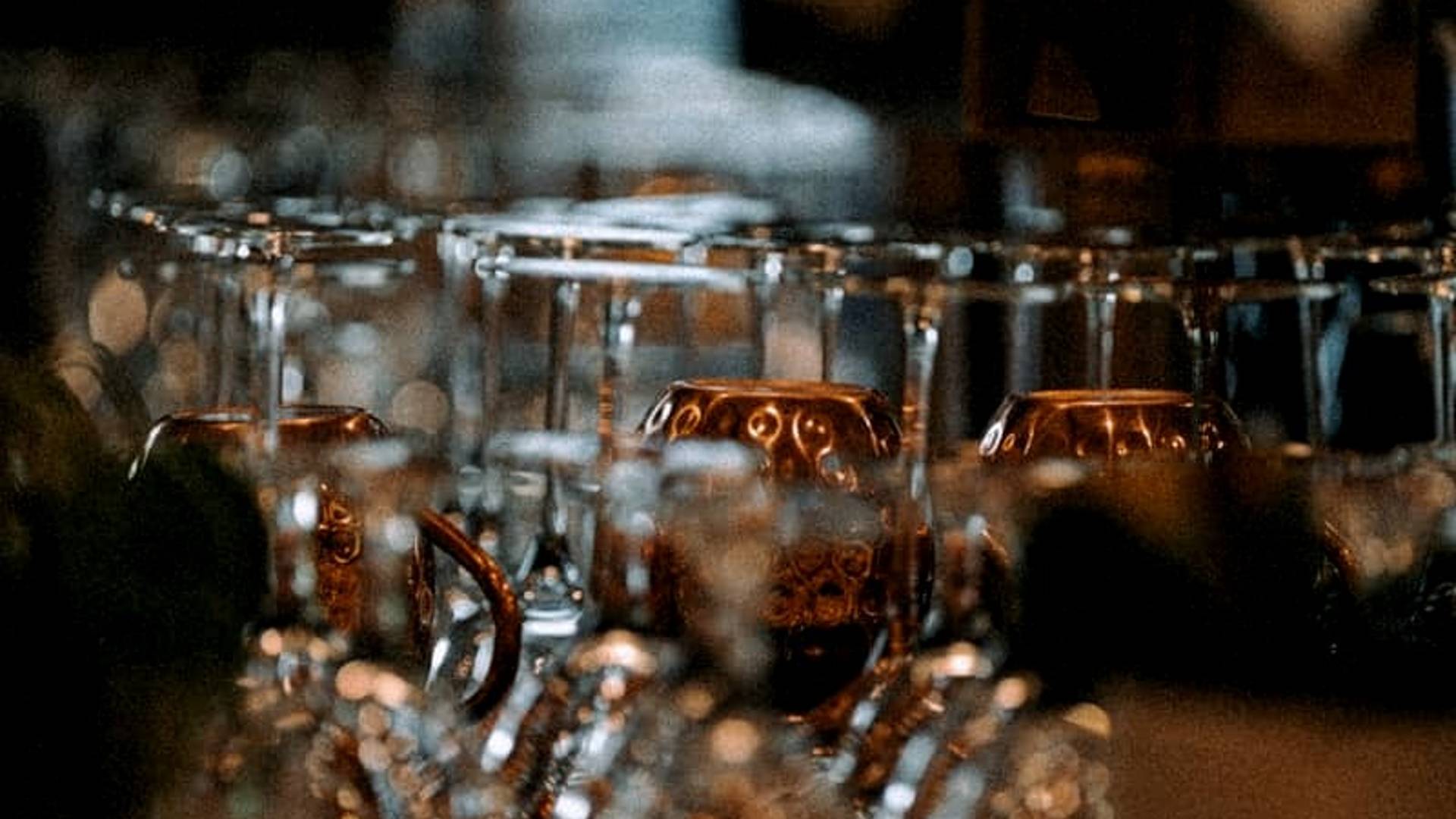 Glasses are arranged on a shelf, ready for use.