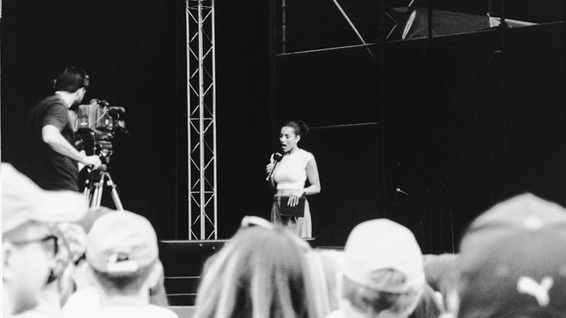 Woman speaking on stage with cameraman