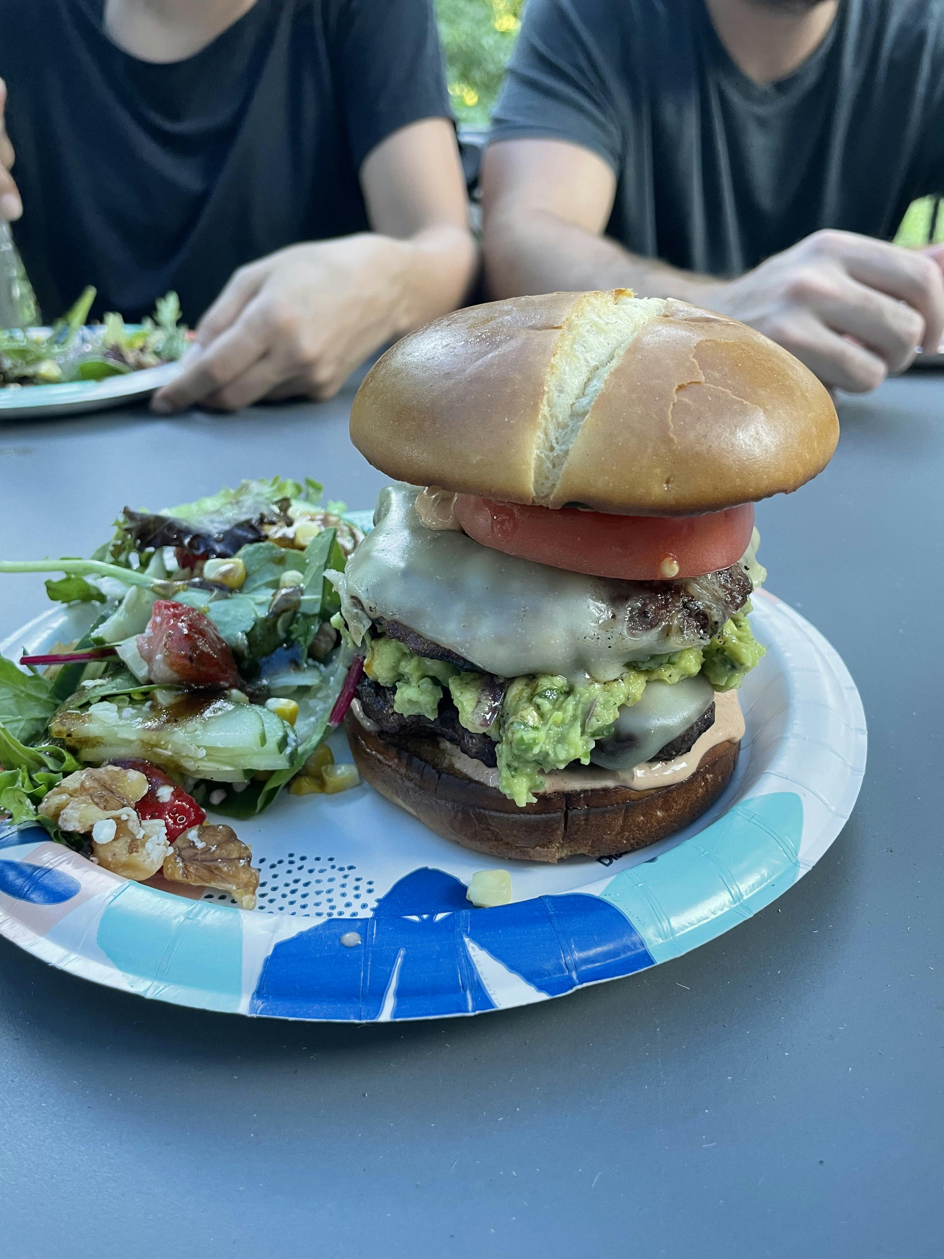 a gorgeous burger on a plate with salad