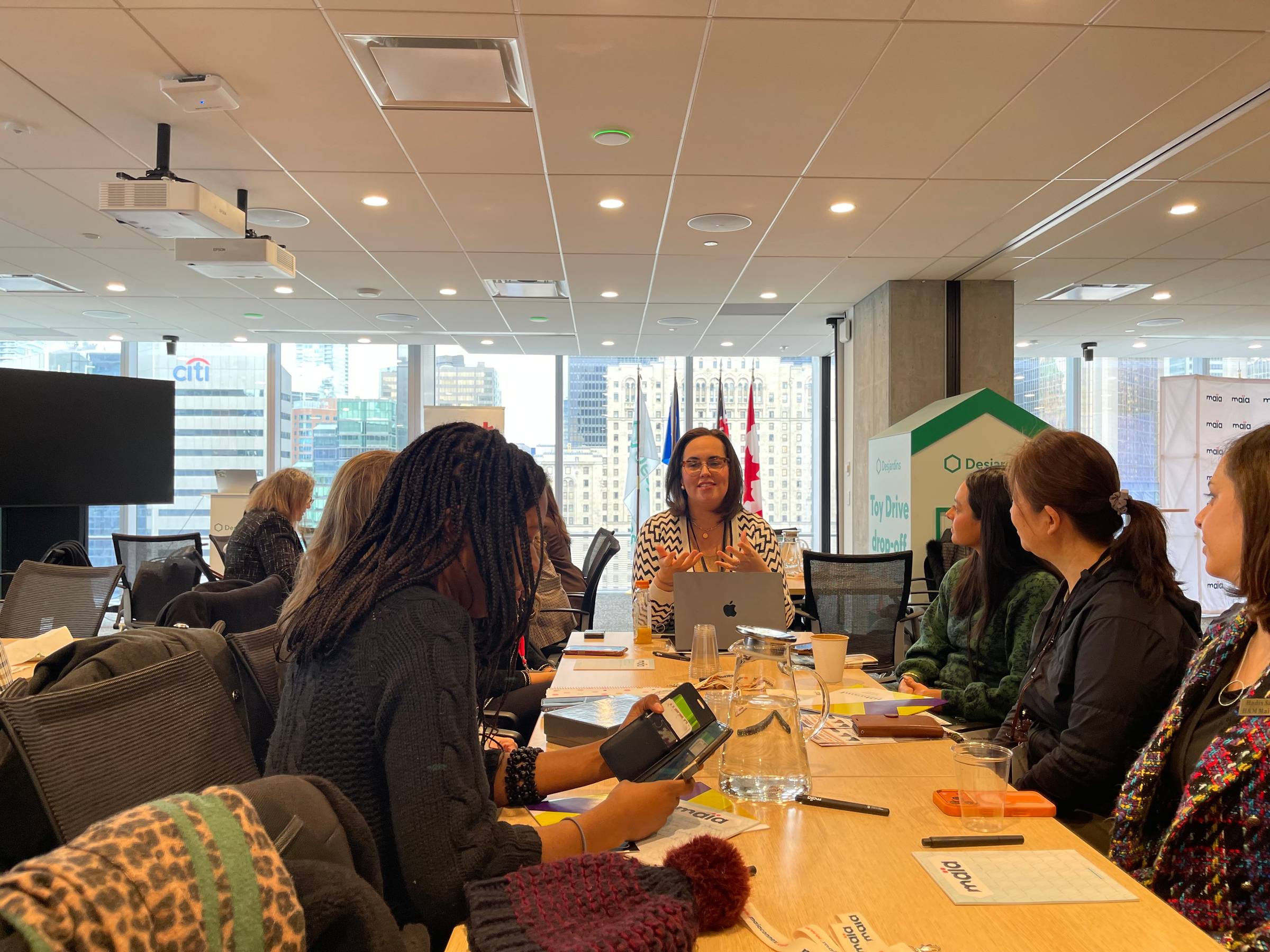 Trina Boos speaking with a group of professionals around a conference table in a city office.