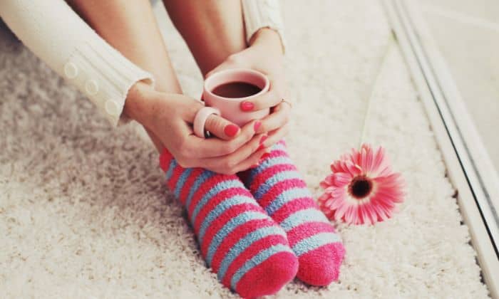 Lady with fluffy socks and cup of tea in had