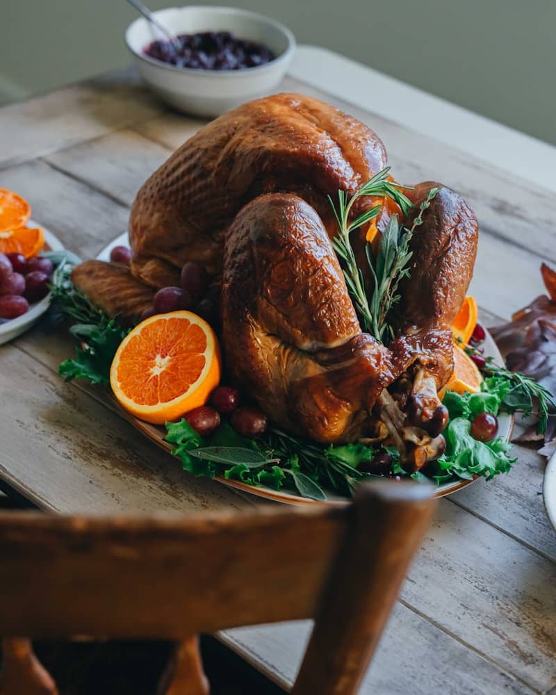A golden roasted turkey garnished with oranges and rosemary.