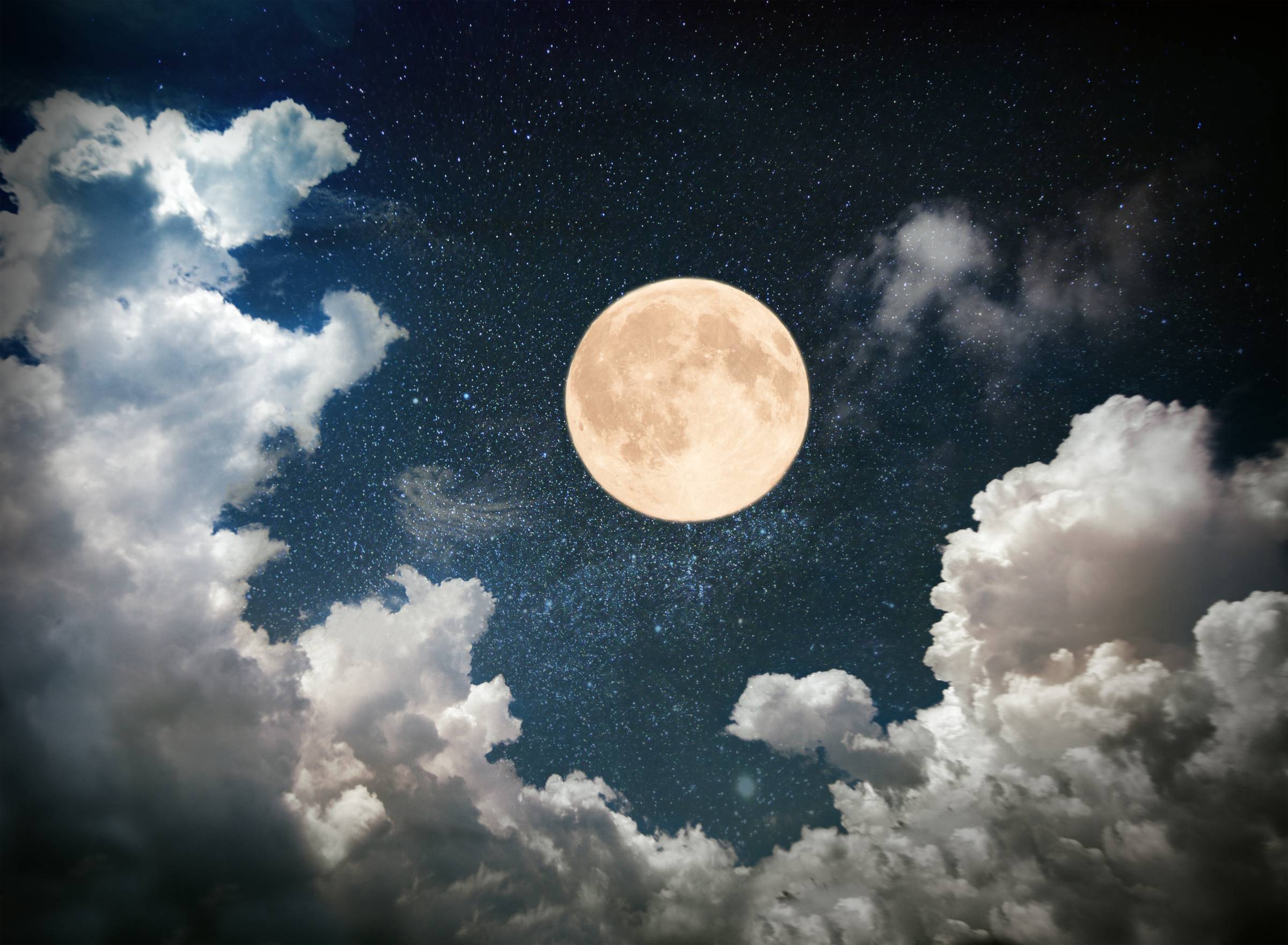 Full Moon surrounded by clouds.