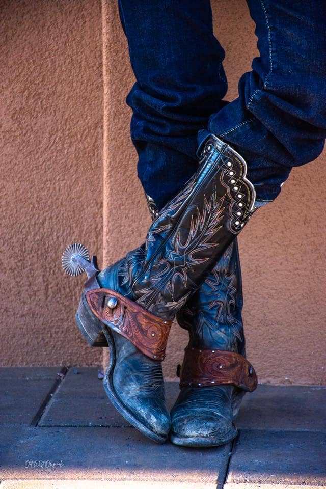 Photograph by Ginger Harter of Out West Originals. Close-up of rugged, well-worn cowboy boots with spurs—capturing the grit, character, and cowgirl spirit behind every step.