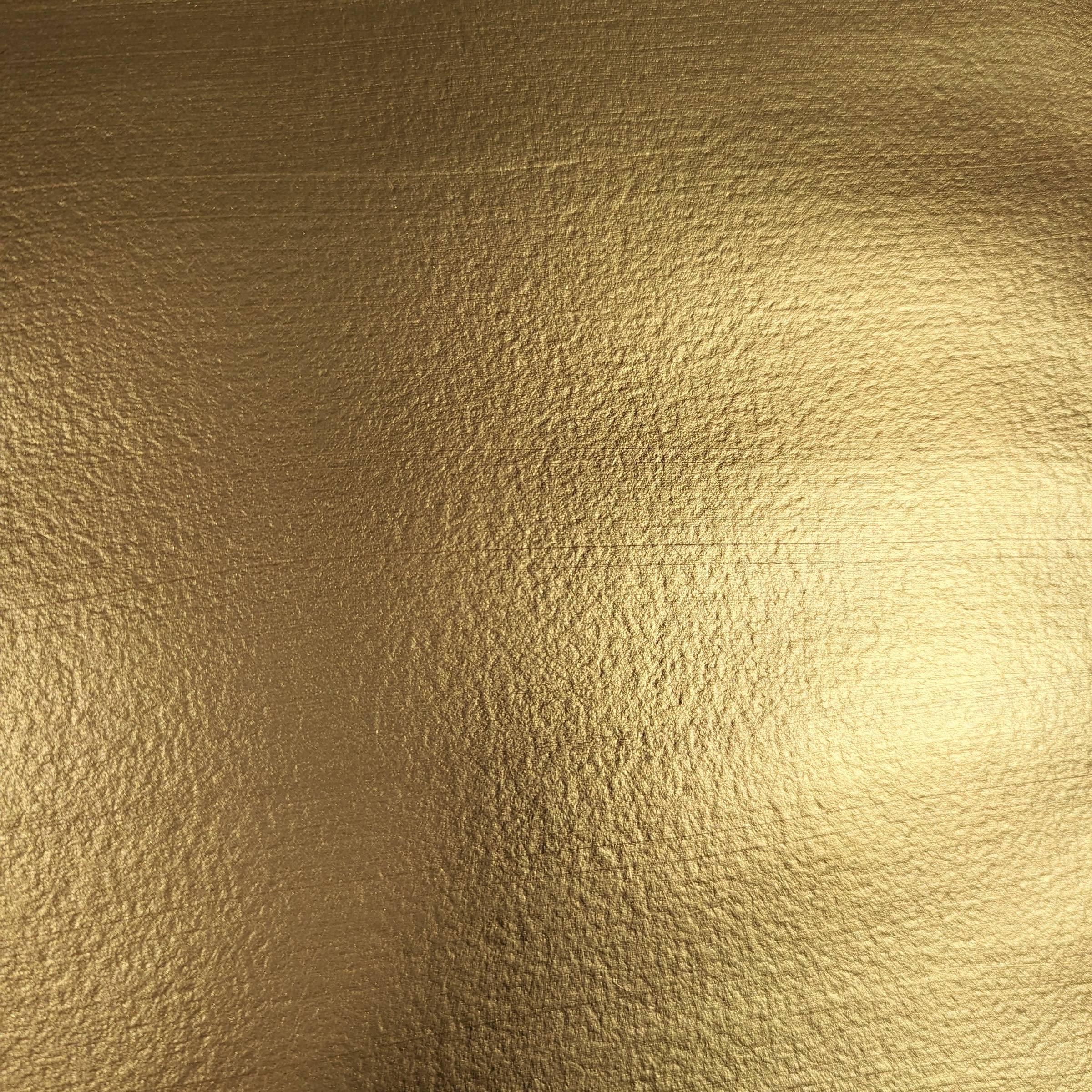 close up of a shimmering gold surface straked with dark shadows