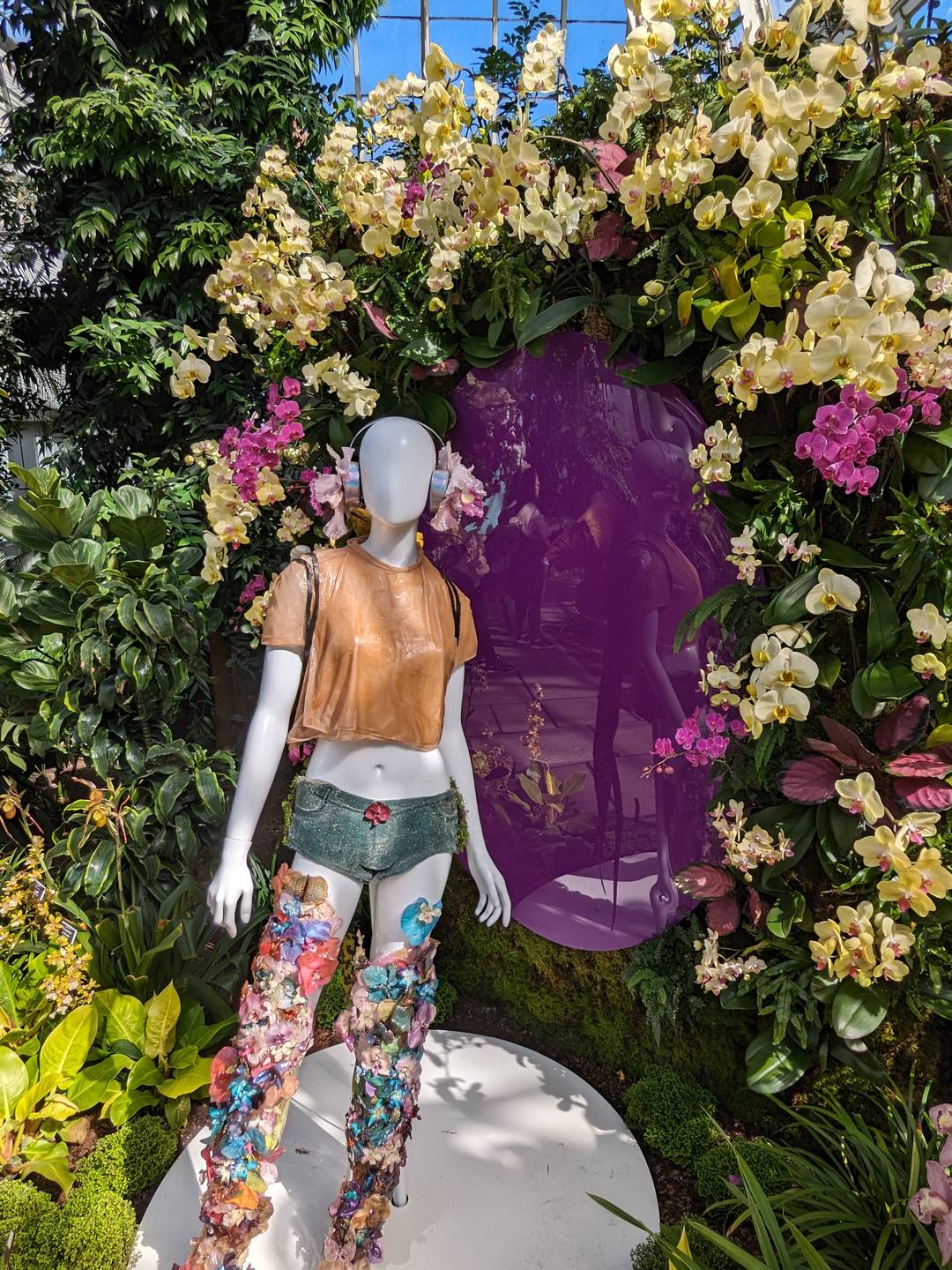 mannequin wearing floral inspired fashion against backdrop of orchids