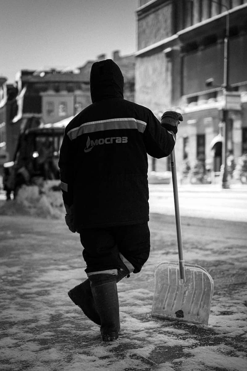 Worker holding a shovel on a snowy street