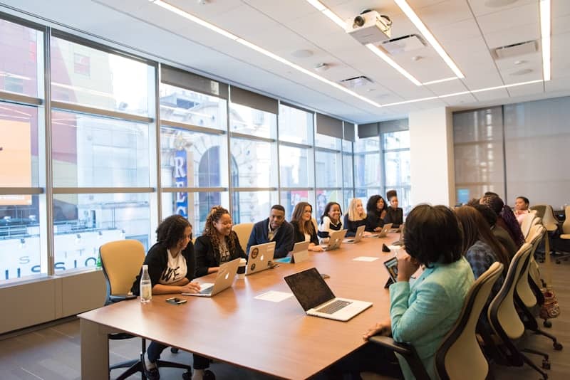 Full length portrait of diverse business team with young woman in wheelchair all smiling at camera in office