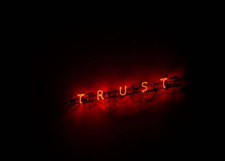 A red trust sign lit up in the dark