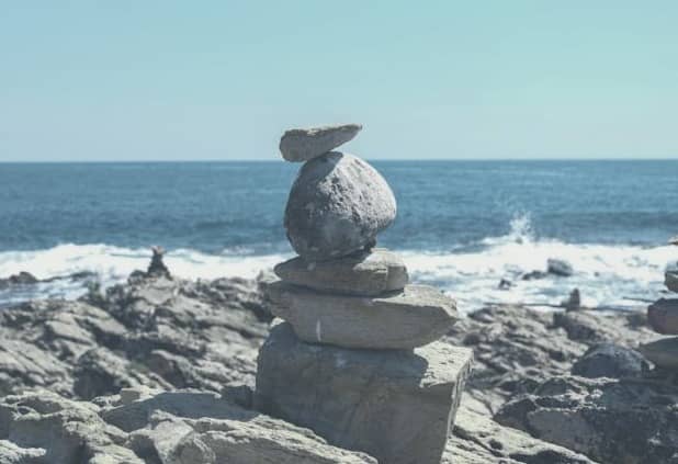 Sescape of blues with a stack of stones on beach