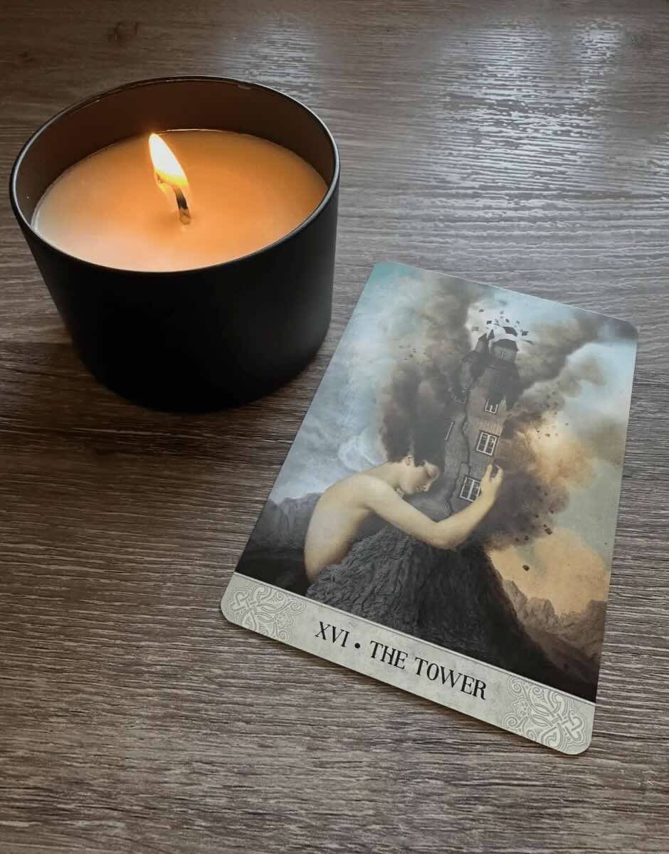 The tower card showing a woman trying to hold up the tower as it falls