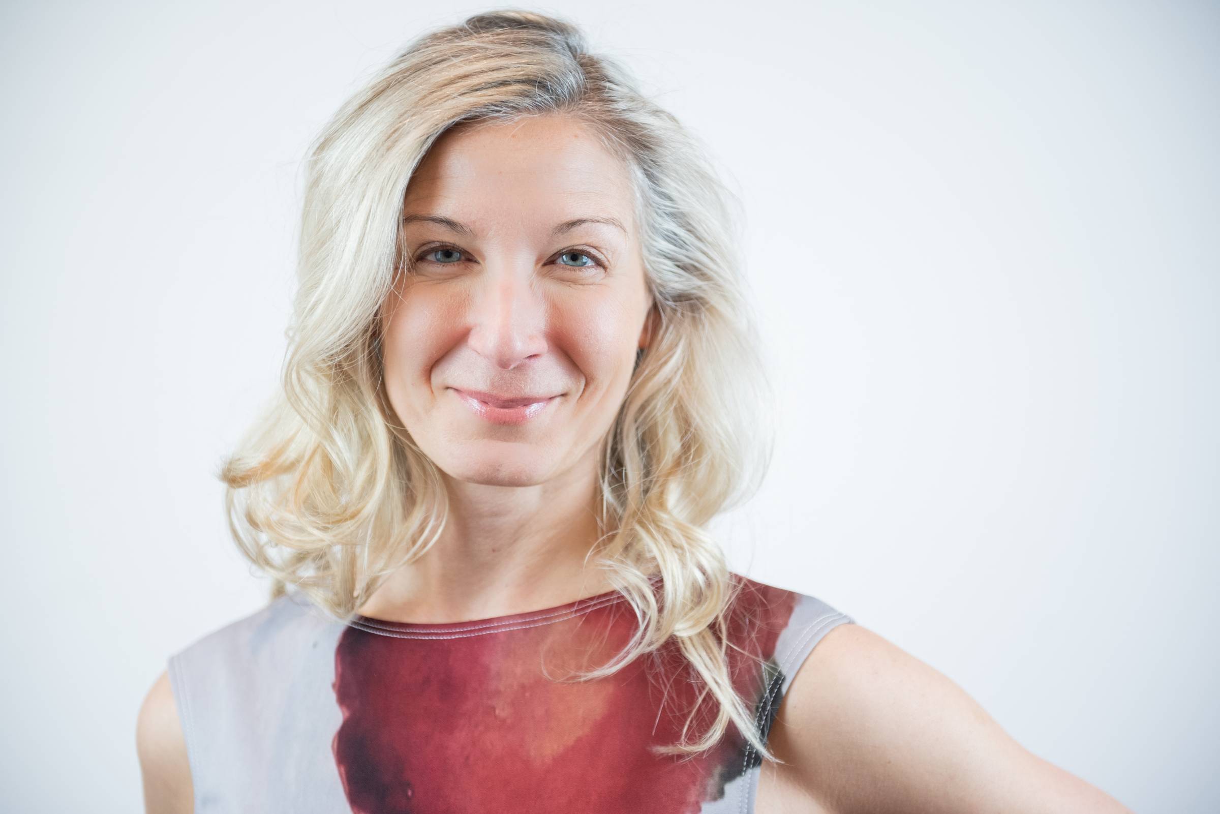 Lana Starchuck is a white woman with blonde hair. She is smiling at the camera in front of a white background