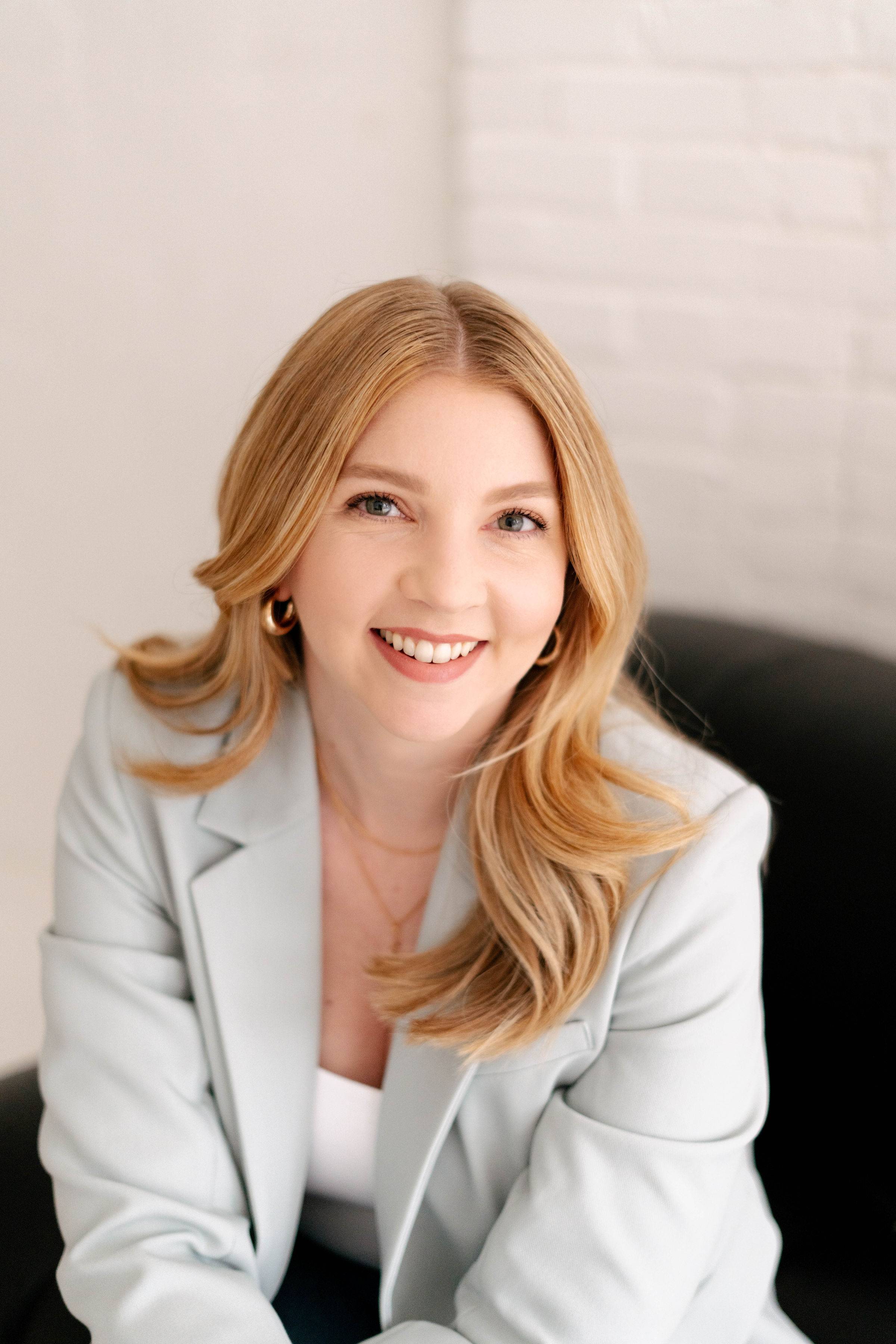 Jessica Moorhouse has long blonde hair and is wearing a light gray blazer.