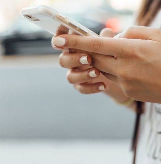 woman holding iPhone during daytime