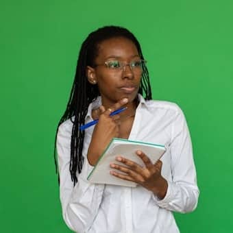 Image of a woman holding a note pad and a pen, looking pensive