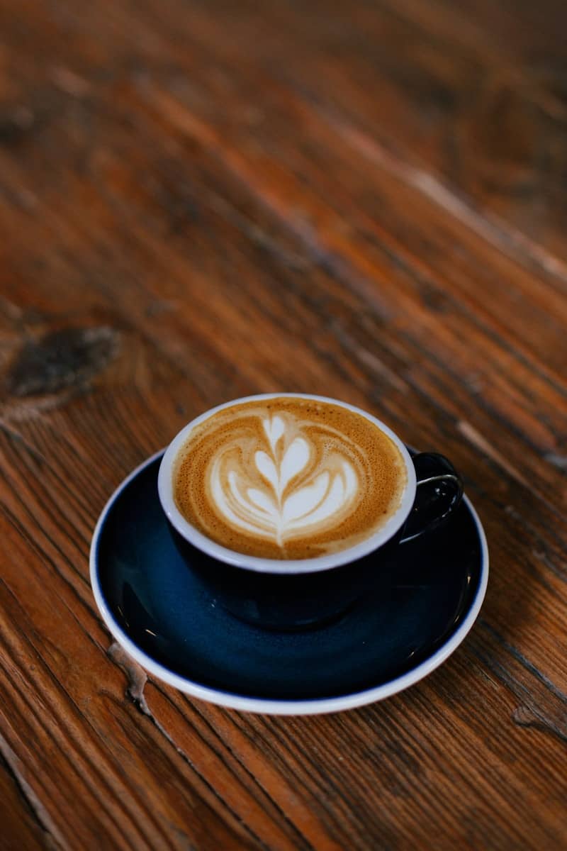 A cappuccino on a saucer on a wooden table