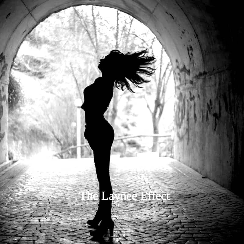 Silhouette of a woman flipping her hair in a tunnel.
