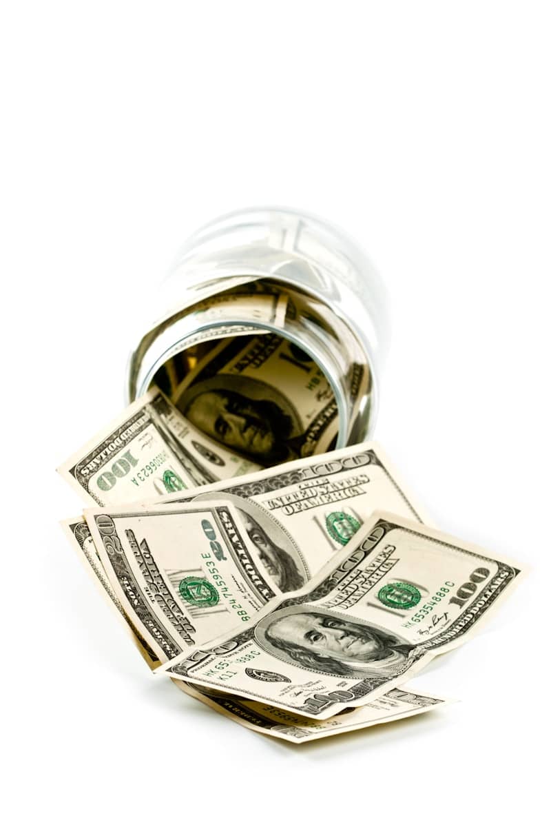 A glass jar filled with money sitting on top of a table