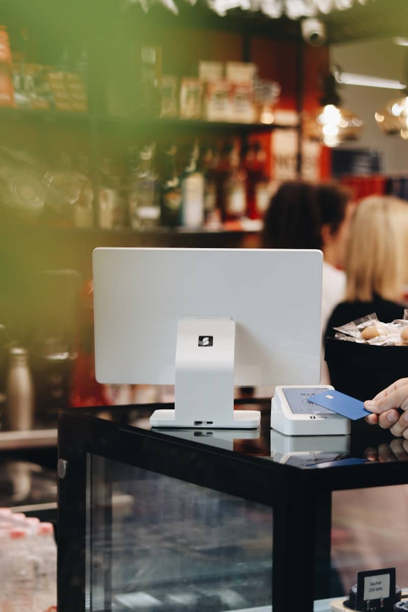A woman is paying at a computer in a store