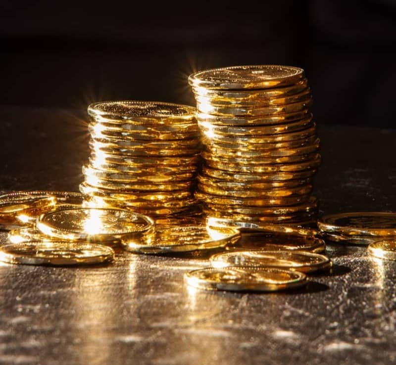 Two stacks of gold coins on a dark surface