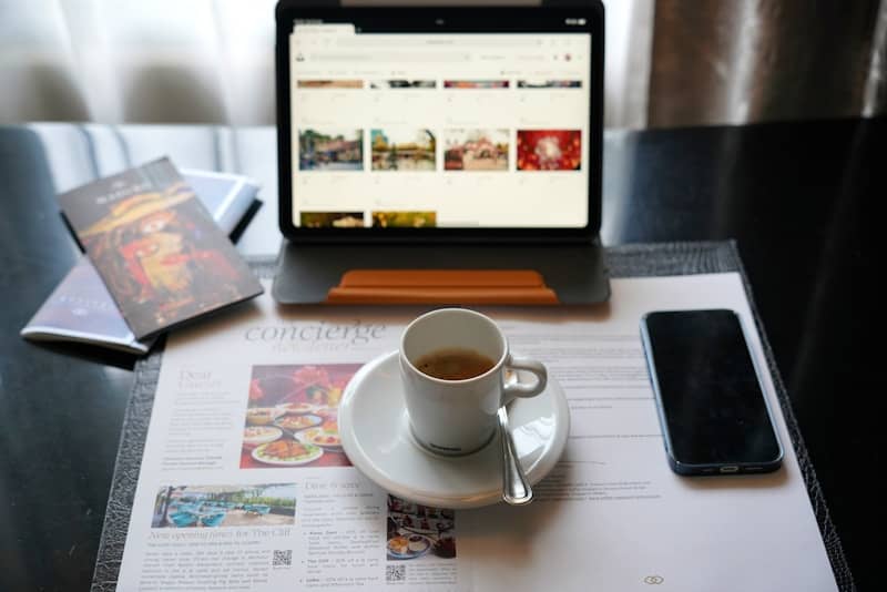 A laptop computer sitting on top of a desk next to a cup of coffee