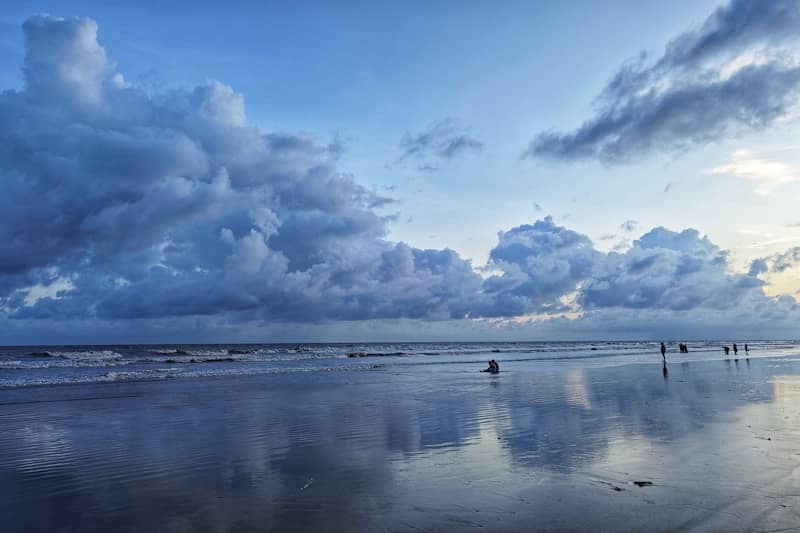 A beach that has some clouds in the sky