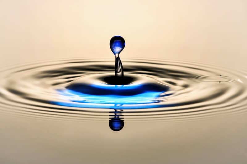 A water drop creates ripples upon impact.