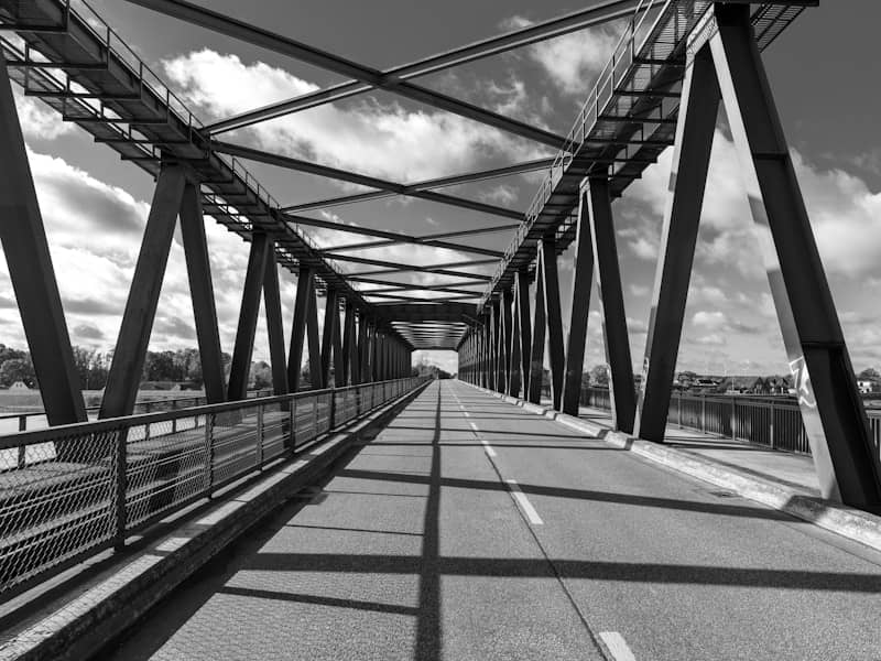 A black and white image of a metal bridge.