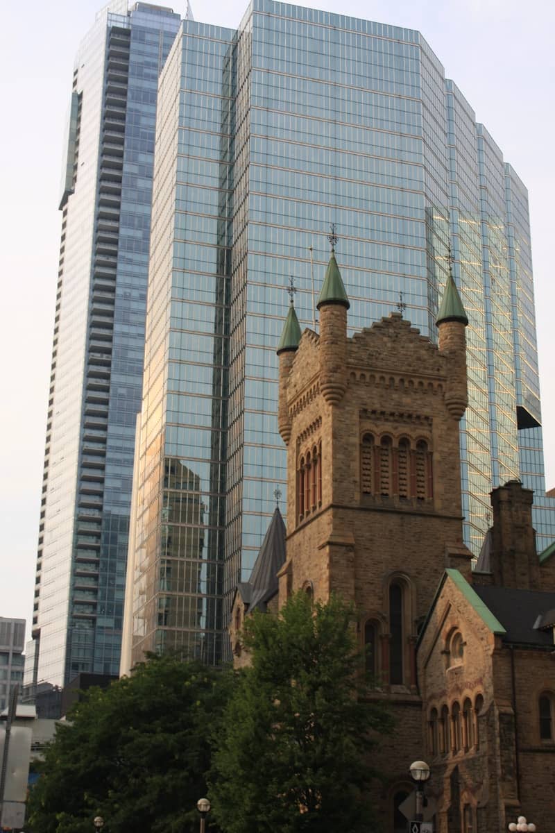 Old stone building beside modern glass skyscrapers