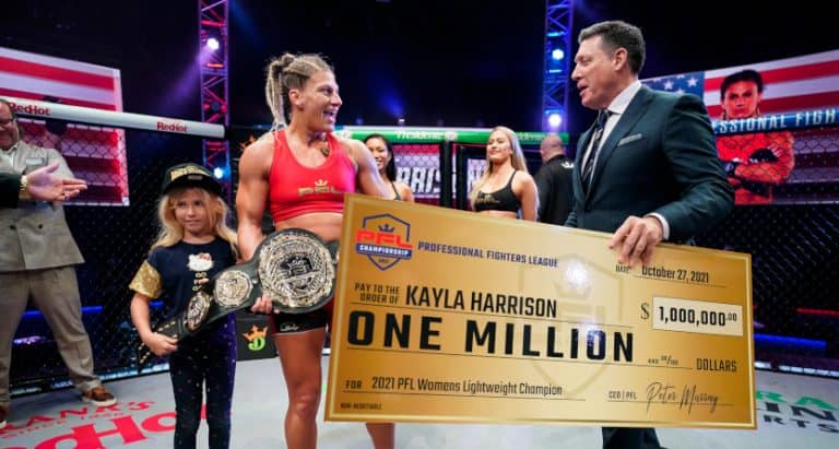 Peter Murray (R) presenting Kayla Harrison with a million-dollar check for a Oct. 2021 Professional Fighters League title. (Cooper Neill/PFL.)