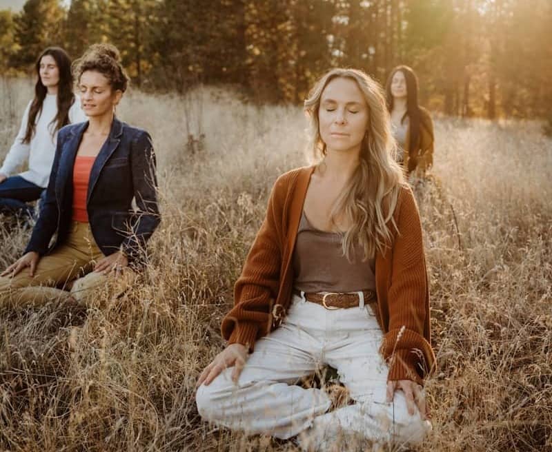 A group of women sitting on top of a grass covered field