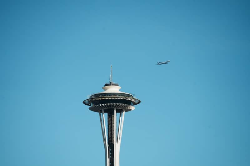 Space needle with airplane flying in blue sky