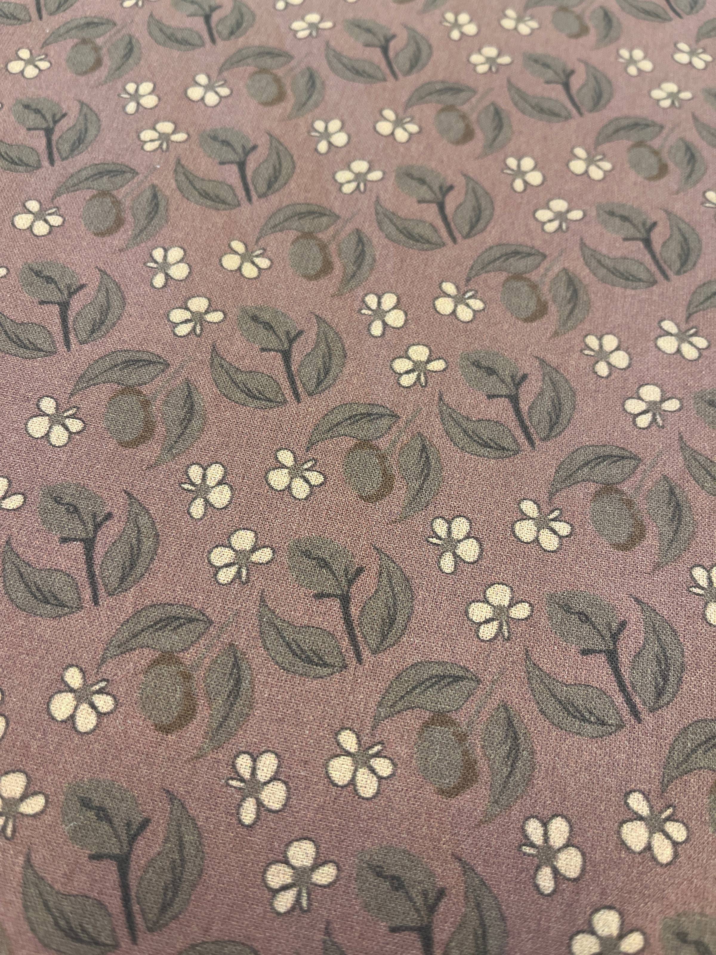 Brunrosa bottentyg med dovt olivgröna blad som blandas med enkla crèmevita blommor.