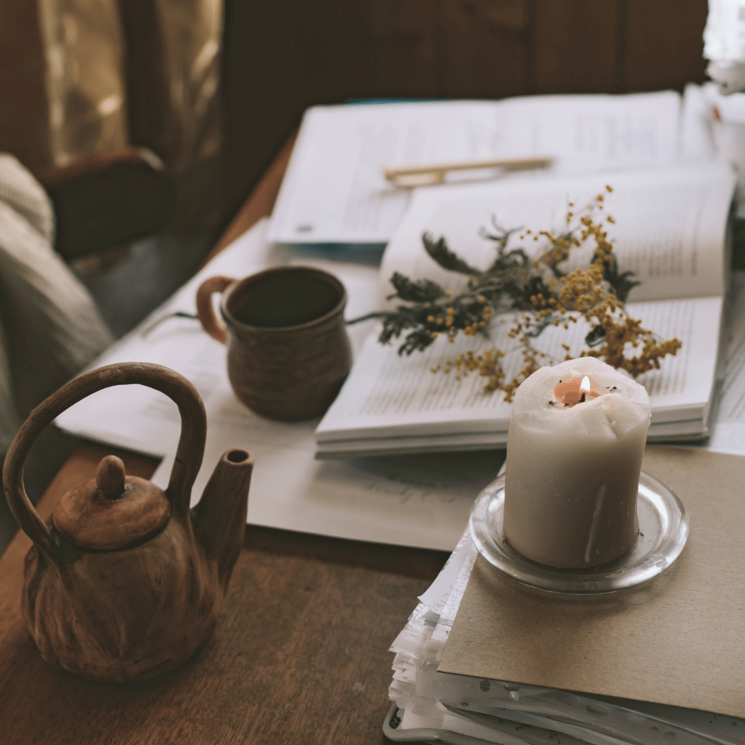 cozy ritual with teapot, tea cup, candle and journal