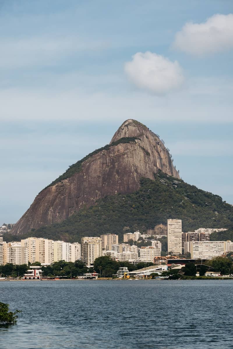 Buildings on the shore with a large mountain behind